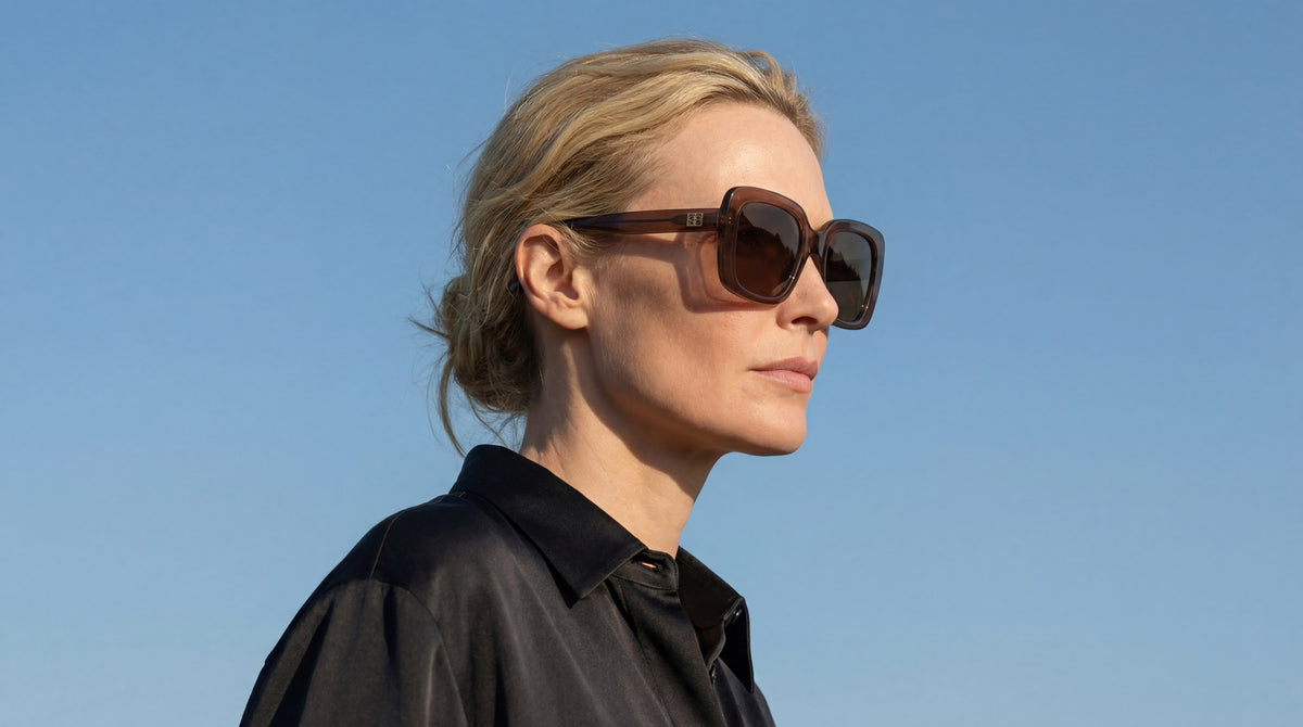 Woman in Mio Chocolate Sunglasses against a blue sky